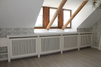 Зашивка Батареї під вікном у мансардній кімнаті. Стільниця та підвіконня виконані з акрилового каменю. Самі решітки -МДФ панелі та вільхові опори